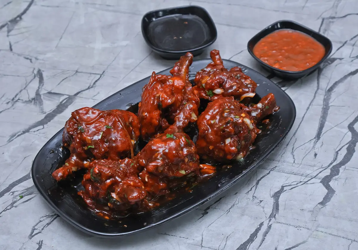 Chicken lollipops tossed in glossy Schezwan sauce